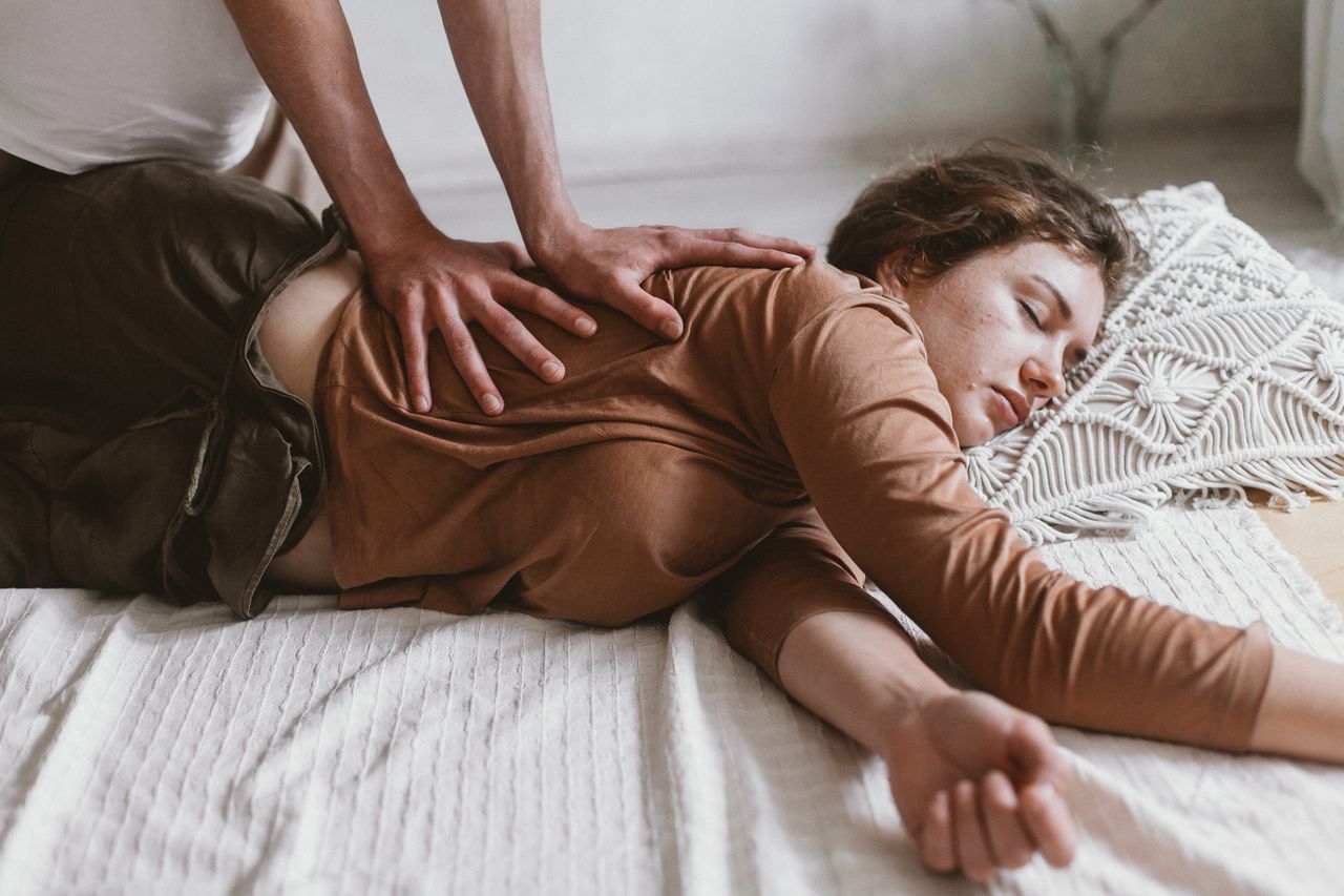 services-01 A calming scene of a woman experiencing relaxation and wellness during a professional massage.